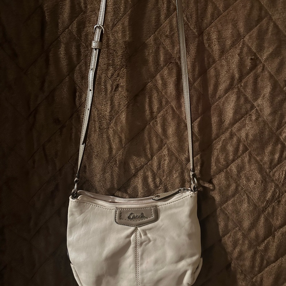 Gently used Coach cream crossbody with rose pink lining, some light pen marks